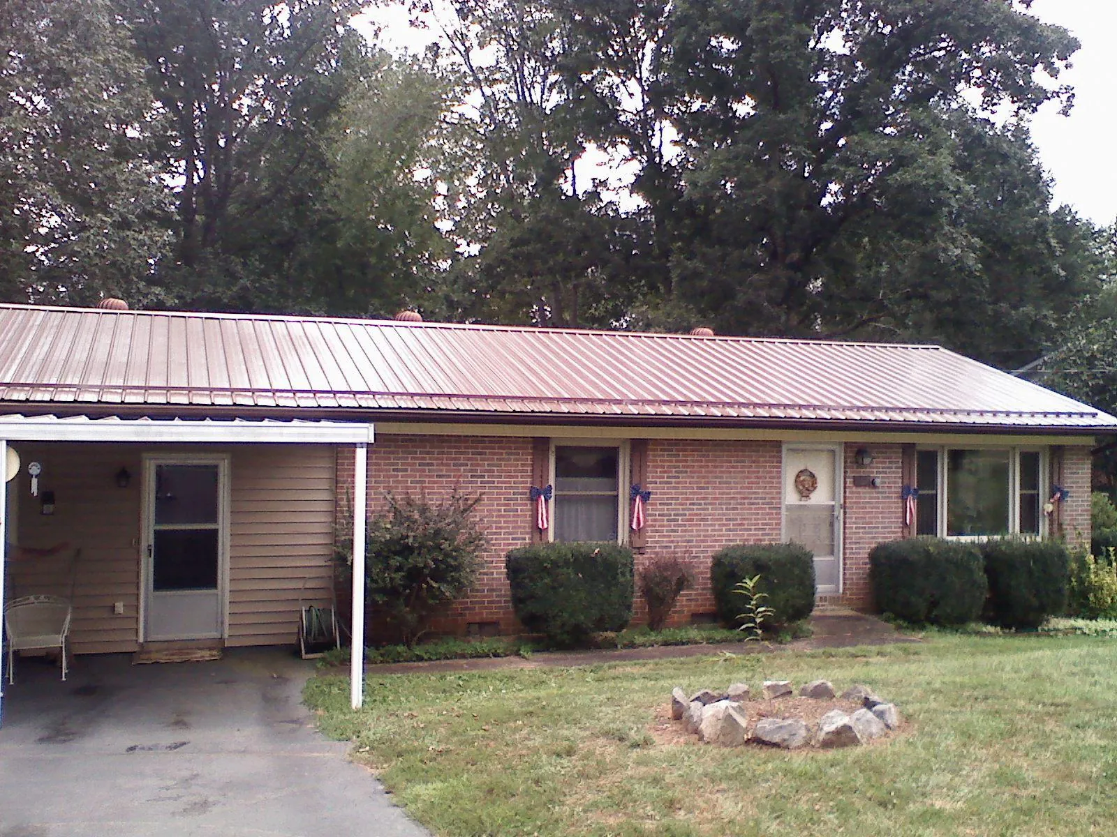 Bronze metal roof and carport on a brick ranch home — Roof Repair work by our crew in Canyon Lake