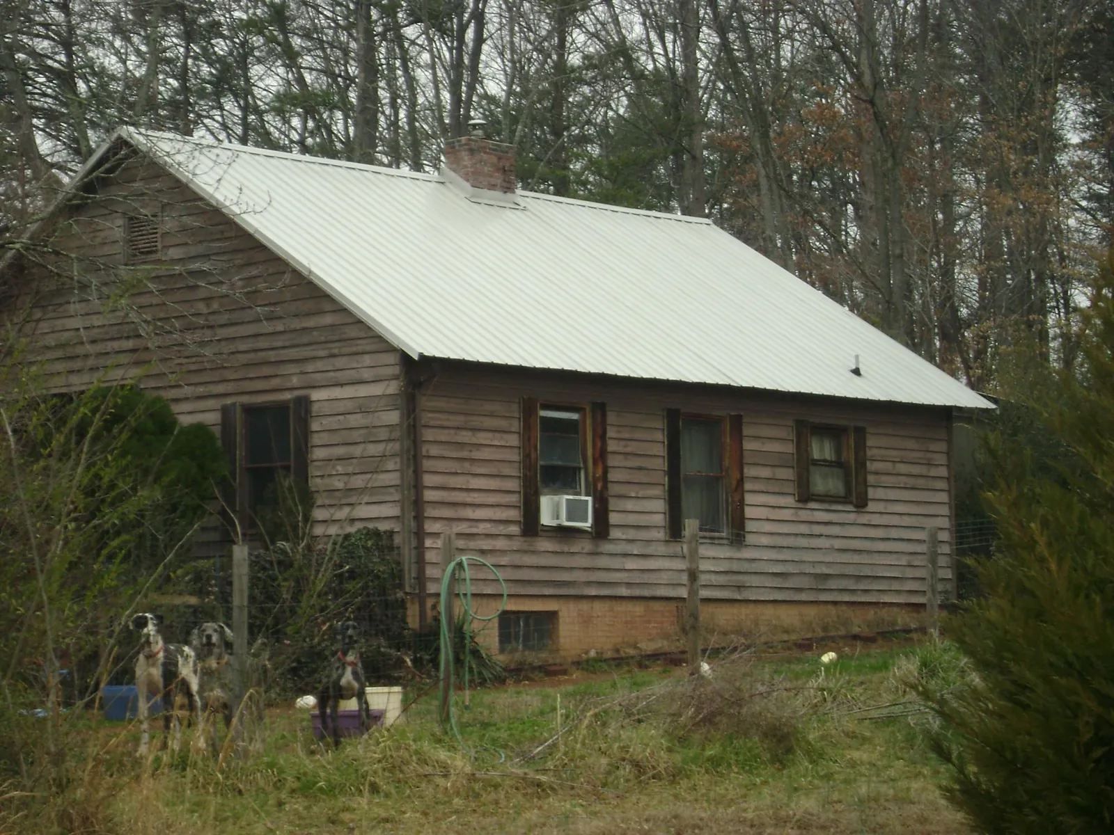 White metal roof on an old wood sided farmhouse, from a Metal Roof Installation job in Canyon Lake